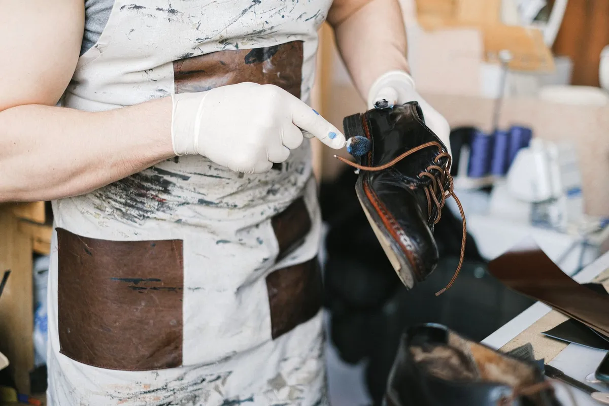 Paire de chaussures en cuir, daim et toile alignée sur un banc en bois